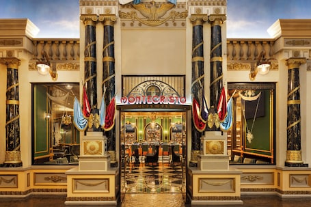 A grand entrance to Montecristo Cigar Bar with ornate columns and a checkered floor.