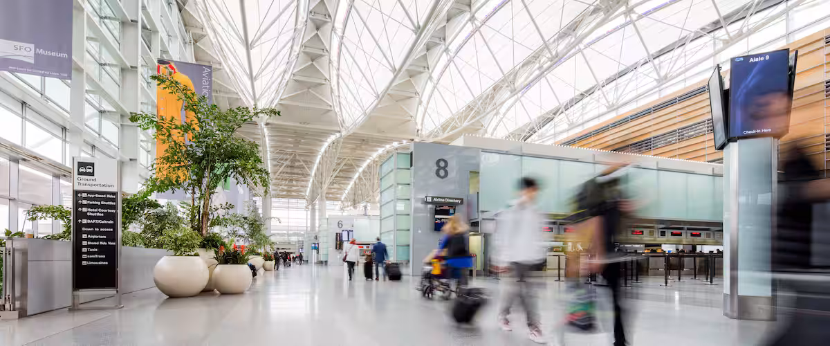 A spacious airport terminal with a high ceiling and natural light.